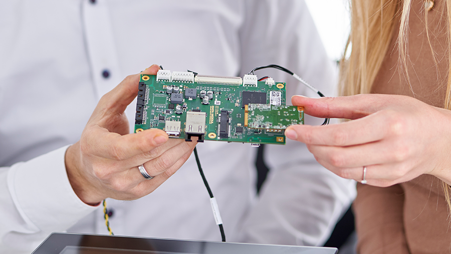 Embedded bei DATA MODUL man and woman holding an embedded board